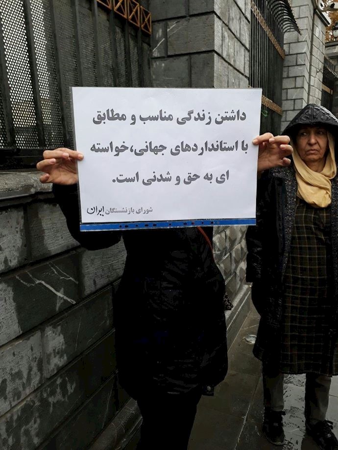 Tehran- a retiree holds a sign saying, “A proper life according to international standards is our feasible just right.” Tehran- a retiree holds a sign saying, “A proper life according to international standards is our feasible just right.”