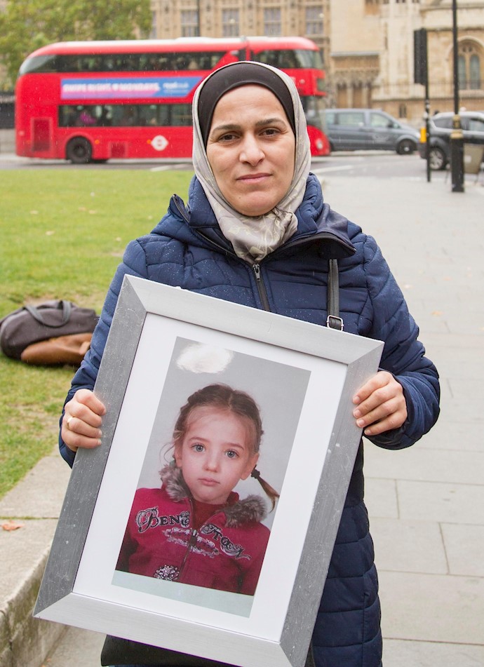 Dr Hala Al Ghawi holds a photograph of one of her colleagues children who was detained Dr Hala Al Ghawi holds a photograph of one of her colleagues children who was detained